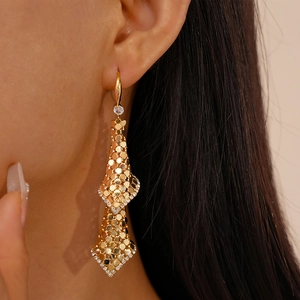 Detail of 18k gold plated mesh earrings with sparkling sequins and zircon on model
