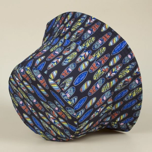 Detail of double-sided bucket hat with colorful surfboard prints and the Ocean Calling text