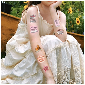 Detail of waterproof temporary reading tattoos on arm with books and quotes