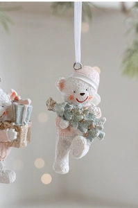 Detailed close-up of a white resin Christmas bear ornament with glitter and ribbon