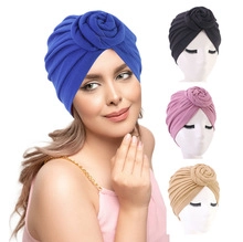 Detail of rose knot and pleated design on elastic solid color turbans in four colors