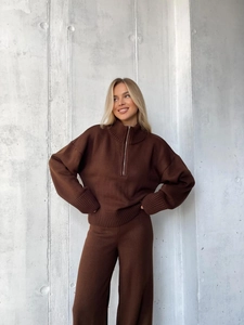 Detail eines dunkelbraunen Stricksets mit Halbreißverschluss und hohem Kragen und Textur
