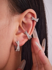 Detailed close-up of a silver-toned crossover ear cuff set with pavé-set sparkling zircons