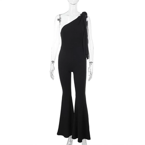 Détail d'une combinaison noire à une épaule avec bretelles et pantalon évasé ajusté