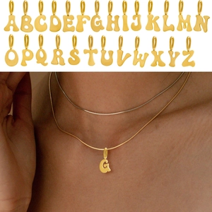 Detail of 26 gold stainless steel alphabet pendants and model wearing the letter G necklace