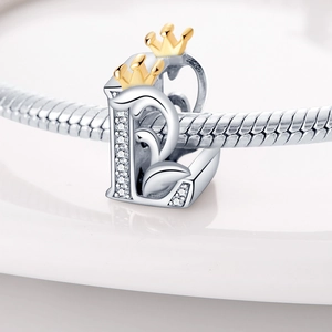 Detailed close-up of a silver letter B charm with CZ stones and a gold crown on a bracelet
