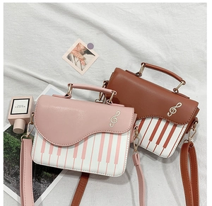 Close-up of piano key pattern and treble clef metal clasp on PU leather crossbody bags