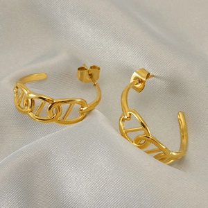 Golden stainless steel chain-link hoop earrings displayed on soft grey silk fabric