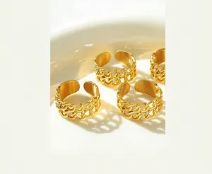 Set of four vintage gold double-layer chain link open rings on a white ceramic plate