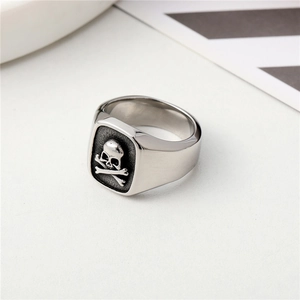 Detailed view of vintage silver skull and crossbones relief on a square steel ring for men