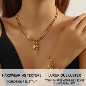 Detail of gold-plated stainless steel Cuban link necklace with crystal flower and lock pendant