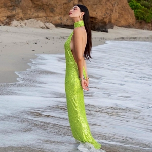 Detail of the backless green sequined evening dress with side cut-out at the beach