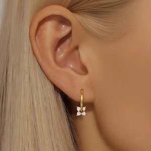 Detail view of a gold S925 silver flower earring featuring clear sparkling gemstones