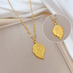 Detailed macro view of a gold leaf-shaped pendant with an engraved character for wealth