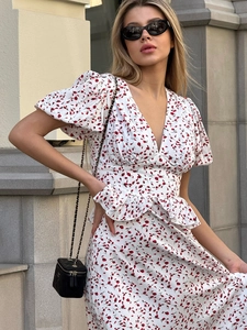 Détail de la robe à fleurs col en V avec manches bouffantes et motifs de fleurs rouges