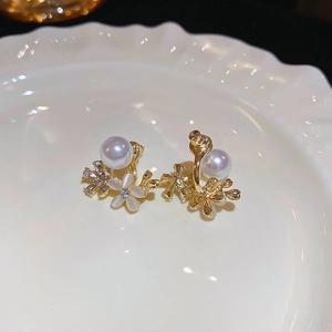 Close-up of pearl flower earrings with cat-eye stone petals and sparkling zircon center