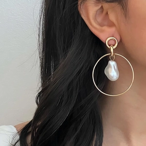 Elegant gold-tone multi-hoop earrings featuring a baroque pearl drop on model