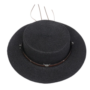 Close-up of black straw hat featuring brown leather band with vintage silver bull head stud