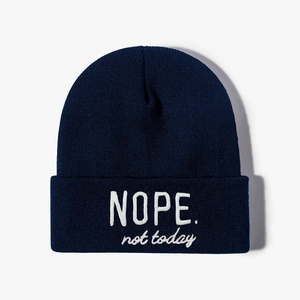 Navy blue knit beanie featuring white NOPE not today embroidery in a street style