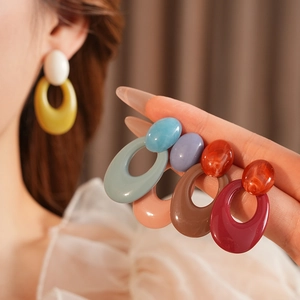 Detailed view of colorful resin oval hoop earrings in various vibrant color combinations