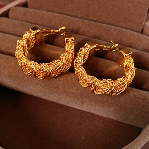 Macro shot of 24k gold-plated hoop earrings with intricate woven texture detail