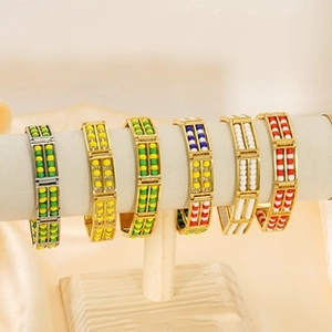 Macro detail of multicolored beaded bracelets on a display stand in gold and silver finish