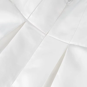 Vue détaillée de la texture du tissu en satin plissé blanc et coutures d'une robe
