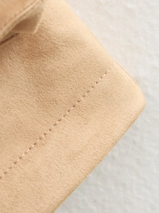 Close-up of tan faux suede jacket detailing the premium texture and fine stitching