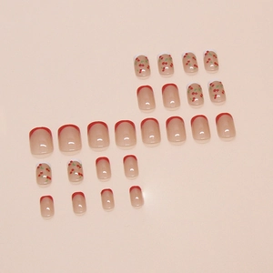 French tip press-on nails set with red cherry hand-painted designs on pink base