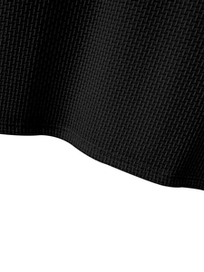 Detailed macro view of black honeycomb waffle knit texture on breathable men's slim fit t-shirt
