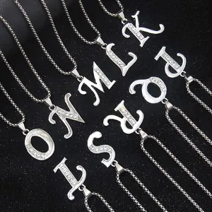 Silver stainless steel alphabet pendant necklaces with diamonds on a black textured background