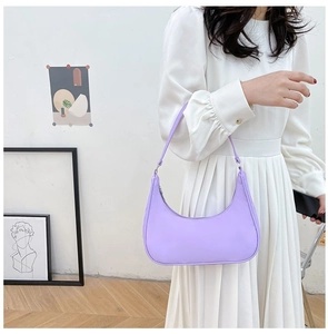 Detail shot of lavender nylon crossbody bag worn with a white dress in a minimalist room