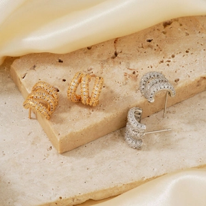 Schicke Gold- und Silber-Creolen mit Zirkonia-Mikropflaster auf Seidenstoff platziert