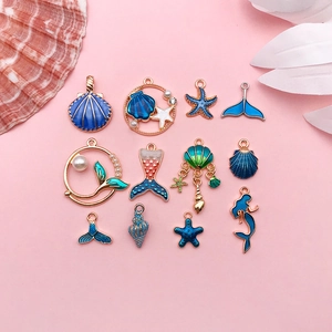 Flat lay of blue and gold ocean charms including mermaid and starfish with pearls