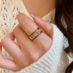 Macro shot of the luxury gold horse logo and brown enamel detail on the open ring