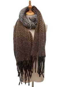 Detail of knit scarf showing textured herringbone pattern and tassel fringe in brown and grey
