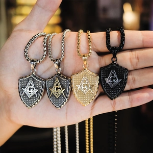 Detail of masonic shield pendants in silver, gold, and black steel finishes on chains