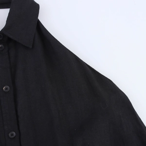 Détail de la texture en lin noir avec col à revers et boutons sur le devant de la robe