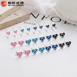 Detail of 925 sterling silver heart-shaped smiley face earrings in various colors