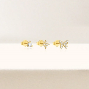 Detailed view of S925 silver gold-plated stud earrings with butterfly and star motifs