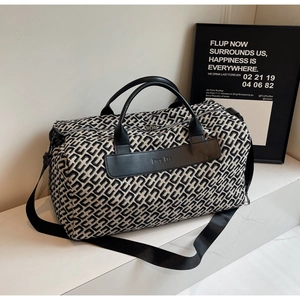 Dettaglio borsa da viaggio con trama geometrica e manici in pelle nera di qualità