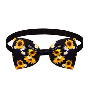 Close-up of dog bowtie with yellow sunflower print on black ribbed fabric and elastic band