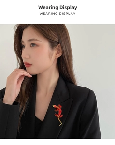 Red crystal lizard brooch pinned on a black suit lapel for a vintage aesthetic look