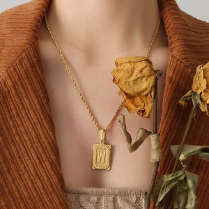 Collana retrò in acciaio al titanio placcato oro 18K con ciondolo lettera W su modella