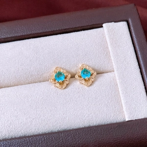 Gros plan des boucles d'oreilles vintage en or avec pierres bleues en boîte