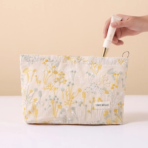 Linen cotton makeup bag with floral embroidery and secure zipper closure for travel