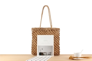 Detail showing the intricate hollow-out mesh weave of a handmade raffia straw tote bag