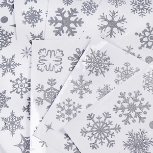 Macro detail of silver glitter snowflake window stickers in various sizes and designs