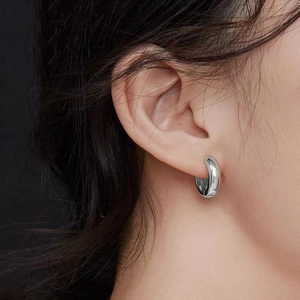 Close-up of minimalist silver hoop earring with 925 sterling silver hallmark stamp