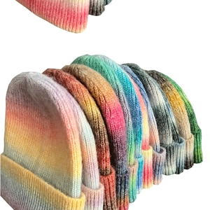 Detail showing various colorful tie-dye gradient patterns on thick knitted winter hats